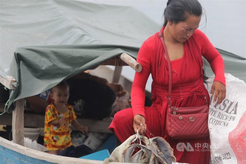 東馬沙巴拿篤漁港邊，終年住在船上的海巴瑤族婦女將曬乾的魚從船上提上岸到市場販賣。中央社記者黃自強沙巴攝 112年7月31日