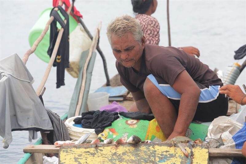 東馬沙巴拿篤漁港邊，海巴瑤族男子在船上向行經的漁販叫賣魚蟹。中央社記者黃自強沙巴攝 112年7月31日