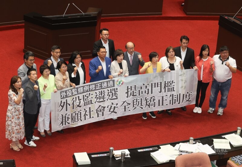 立法院31日三讀修正通過外役監條例部分條文,提高遴選門檻,受刑人須符合有期徒刑執行逾1/3等3種情形,才能參加遴選。圖為民進黨立委在議場內持標語合影。中央社記者謝佳璋攝 112年7月31日