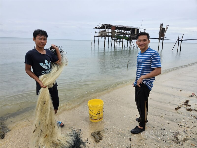 東馬沙巴拿篤油棕園區靠海漁村，屬於蘇祿族的無國籍少年利用漁網在海邊捕魚，維持生活所需。中央社記者黃自強沙巴攝 112年7月31日