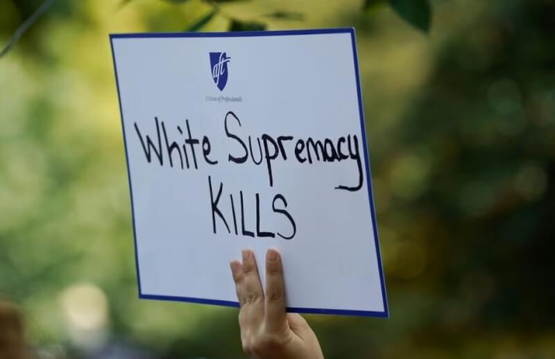 西方社會的種族歧視議題十分複雜且敏感。圖為2019年美國華盛頓州一名女子在遊行中高舉反對白人至上主義標語。（路透社）
