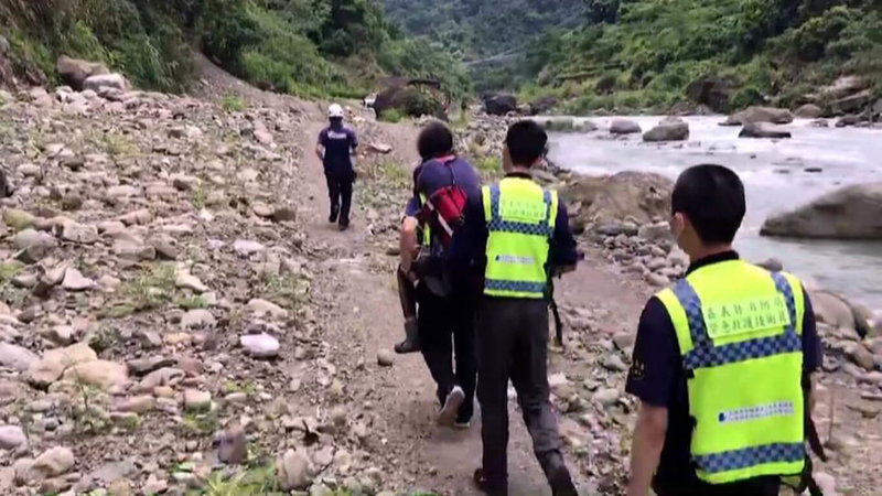 嘉義縣阿里山鄉山美大橋下1日一行人溯溪發生2女1男遭溪流沖走意外，所幸漂流500公尺後在淺灘區獲救，未發生重大事故，當中僅有蔡女頭部撞傷，由救護人員從溪谷岸邊攙扶揹負至救護車上送醫。（嘉義縣消防局提供）中央社記者黃國芳傳真  112年8月1日