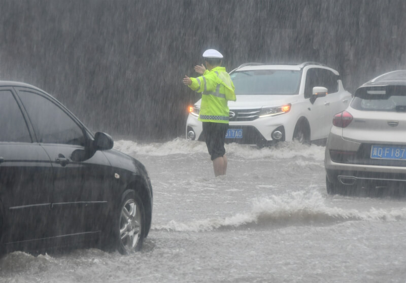 圖為30日河北邯鄲市豪雨成災，警察疏導交通。（中新社）