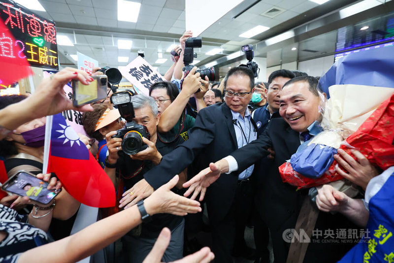 國民黨總統參選人侯友宜（前右）2日結束訪日行程，下午搭機返抵台北松山機場，現場許多支持者接機，獻花致意並爭相盼與侯友宜握手。中央社記者趙世勳攝  112年8月2日