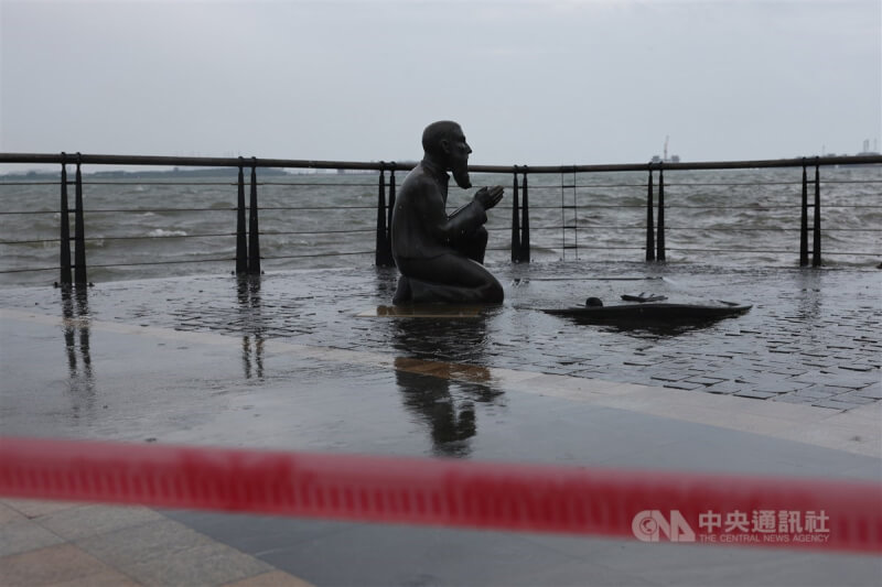 颱風卡努逼近台灣，風雨逐漸增強，新北市淡水老街3日上午出現河水溢過路面的景象，馬偕藝術銅像周圍也拉起封鎖線，避免民眾發生危險。中央社記者趙世勳攝 112年8月3日