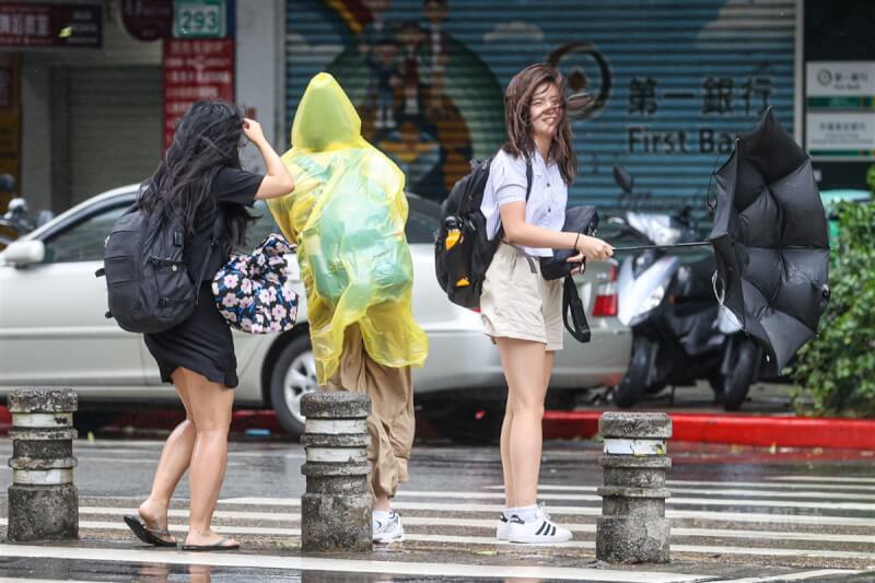 圖為台北市中正區午後陣風將民眾雨傘吹開了花。中央社記者鄭清元攝 112年8月3日
