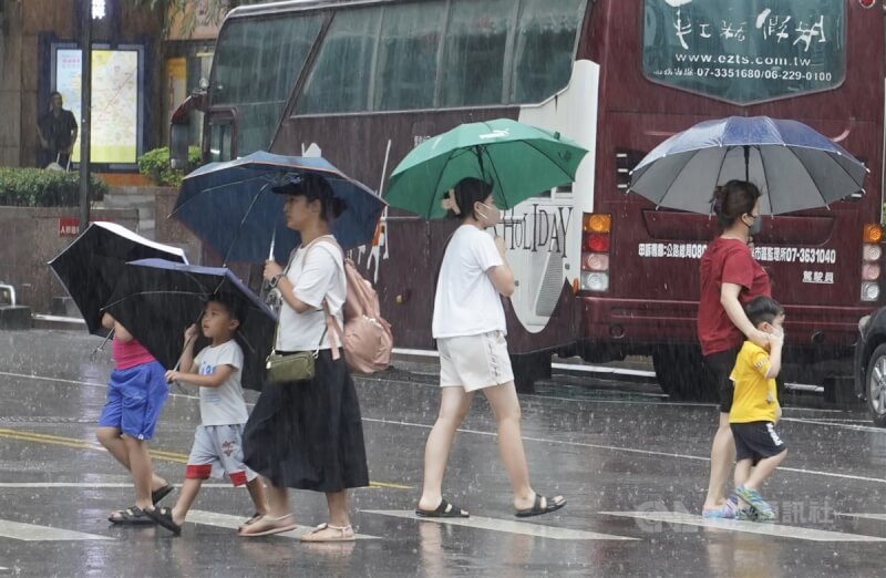 颱風卡努陸上及海上警報解除，但受颱風外圍環流影響，中央氣象局提醒，5日、6日嚴防豪雨大雨。圖為高雄苓雅區民眾撐傘遮擋雨勢。（中央社檔案照片）