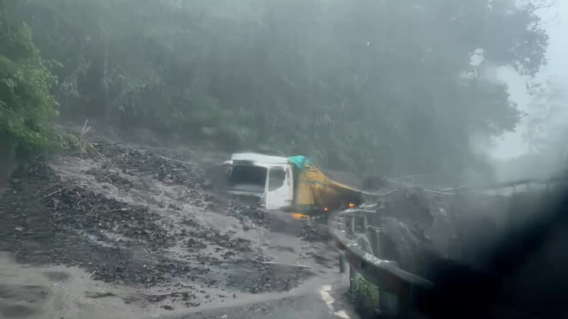 颱風卡努影響，南投縣仁愛鄉4日雨勢不斷，鄉內多處道路出現泥流，「投89線」力行產業道路有貨車遭土石流掩埋半個車身（圖），所幸駕駛逃出。（翻攝畫面）中央社記者蕭博陽南投縣傳真 112年8月4日