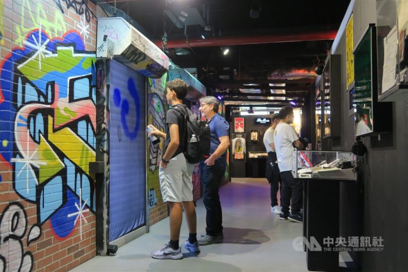 紐約嘻哈黃金年代特展呈現嘻哈文化不可少的街頭塗鴉，以特製設備讓訪客體驗任意在牆上噴漆是什麼滋味。中央社記者尹俊傑紐約攝 112年8月5日