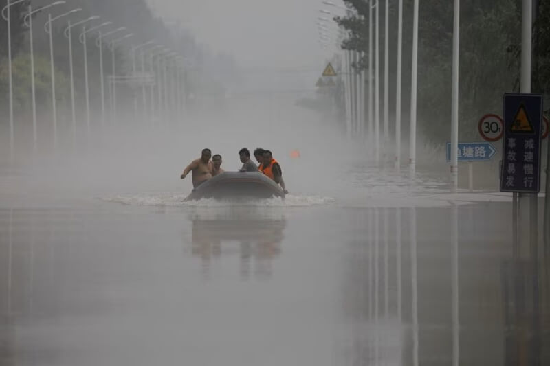 圖為涿州市境內8月3日仍見積水，災民以橡皮艇移動。（路透社）