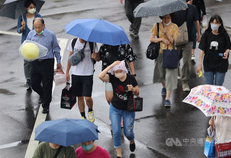 氣象局表示，7日迎風面中南部不定時有短暫陣雨或雷雨，南部地區及中部山區仍易有局部大雨，台北盆地及花東縱谷內則須留意局部攝氏38度高溫發生。圖為台北市中山區午後下起陣雨，民眾撐傘快步過馬路。（中央社檔案照片）