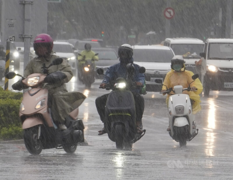 圖為高雄市新興區街頭機車騎士頂著雨勢前進。（中央社檔案照片）