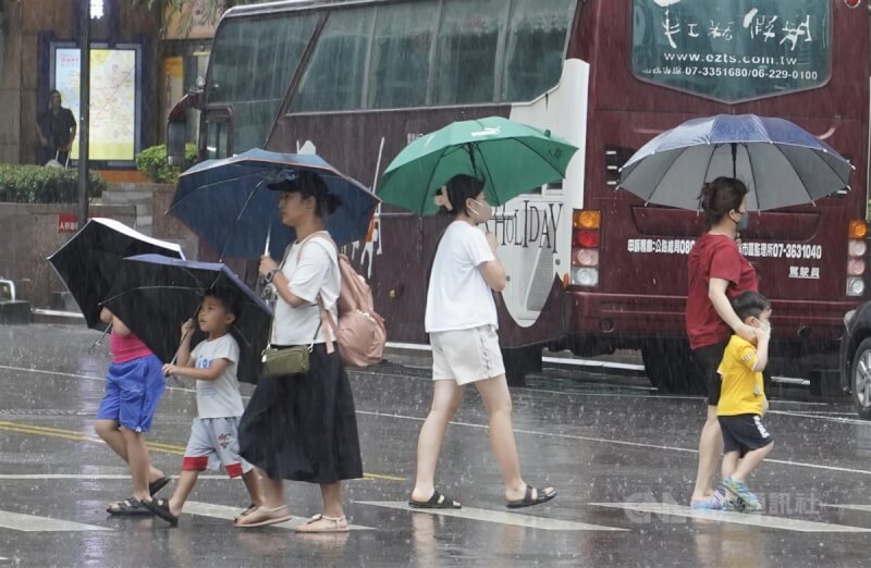 圖為高雄苓雅區下起短暫陣雨，民眾紛紛撐傘遮擋雨勢。（中央社檔案照片）