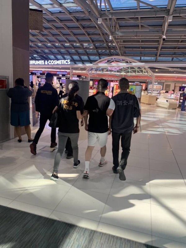 「88會館」負責人郭哲敏(黑衣白褲者)潛逃海外被通緝,7月下旬在曼谷遭泰國警方逮捕,8月10日在刑事局和調查局人員押解下,從曼谷蘇凡納布機場返台。(駐泰代表處提供)中央社記者呂欣憓曼谷傳真 112年8月10日