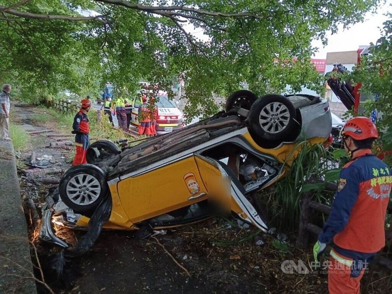 新北市新店區環河路11日下午有計程車疑下雨打滑失控，整台車翻覆並衝進路旁草叢，車內3人受傷，其中林姓乘客左手骨折，都已送醫治療。（翻攝照片）中央社記者高華謙傳真  112年8月11日