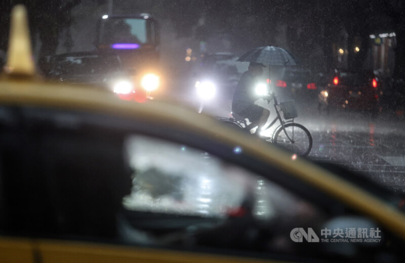 中央氣象局10日下午針對台北市等縣市發布大雷雨即時訊息，慎防劇烈降雨以及低能見度。圖為大安區民眾一邊騎腳踏車一邊撐傘避雨。中央社記者張新偉攝 112年8月10日