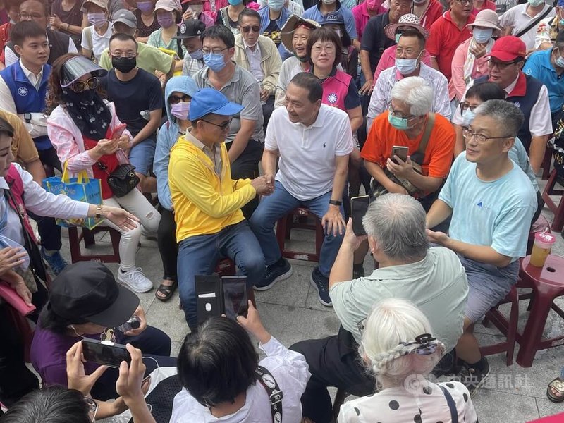 國民黨總統參選人侯友宜（前中，白衣者）12日走訪台南，上午在北區大觀音亭暨興濟宮前與支持者交談、握手致意。中央社記者張榮祥台南攝  112年8月12日