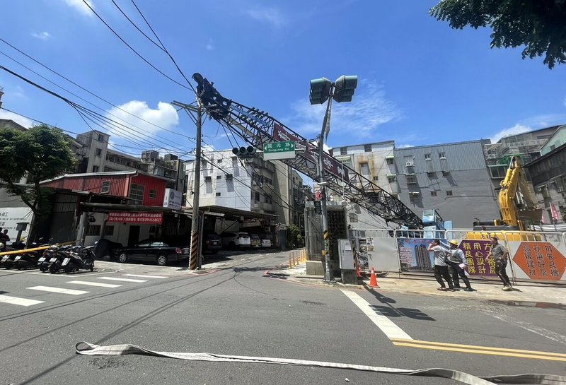 新北市永和區國光路一處工地12日施工時，吊車不慎滑落地下室，造成吊臂傾斜砸壞電桿，周邊住戶1405戶停電。新北市消防局表示，除通知台電搶修，也由警方封鎖周邊道路管制。（民眾提供）中央社記者黃旭昇新北傳真  112年8月12日