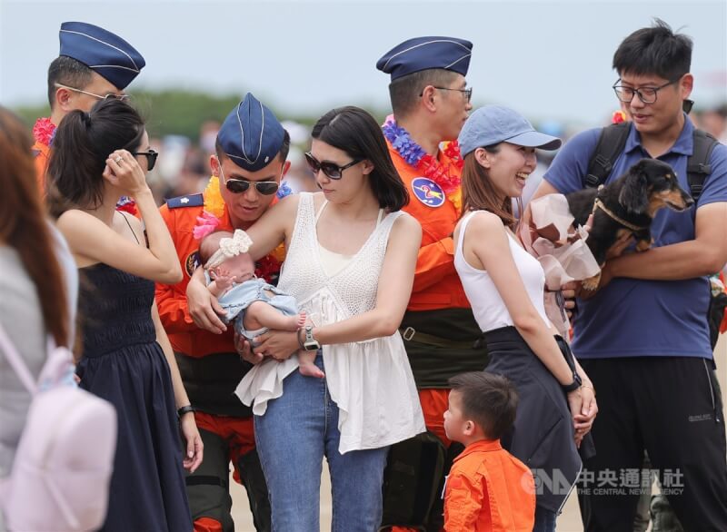 空軍台中清泉崗基地「航空嘉年華」活動12日熱鬧展開，順利完成操演操演項目的飛官在任務結束後列隊到觀禮台，與家人親友一同分享喜悅。中央社記者裴禛攝 112年8月12日