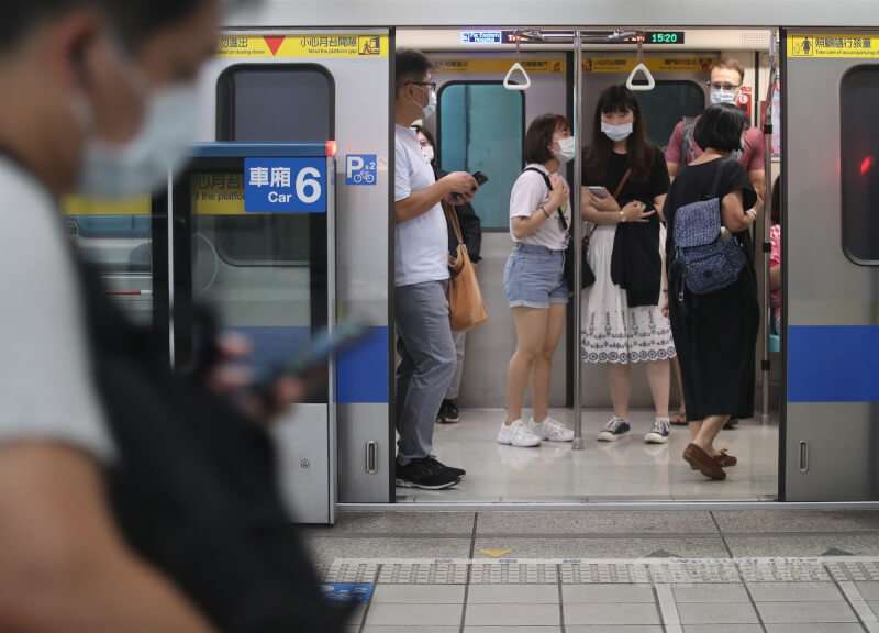 台北捷運12日表示，列車空調已設定為夏季模式，平日尖峰時間為攝氏23度。圖為民眾戴口罩搭乘台北捷運。（中央社檔案照片）