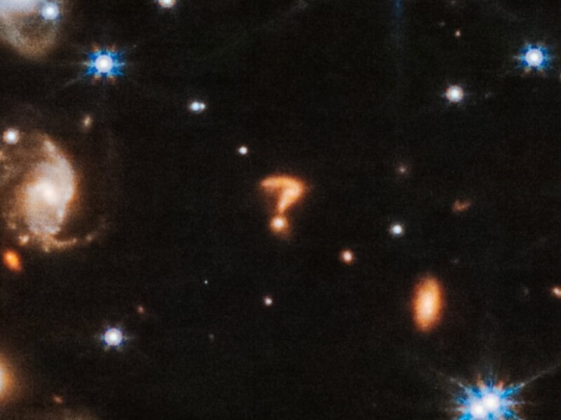 NASA韋伯太空望遠鏡捕捉到的最新影像中，出現一個閃閃發光的問號形狀物體，科學家認為這是兩個星系相互碰撞的結果。（圖取自twitter.com/esa）