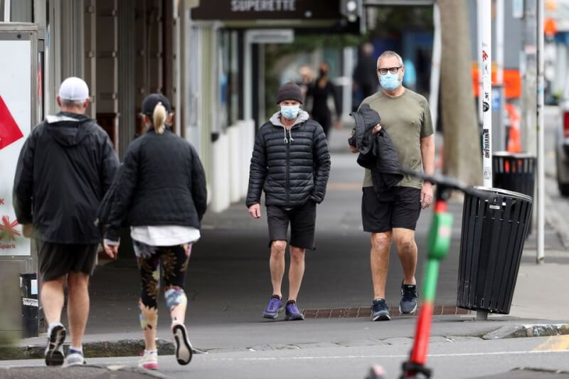圖為紐西蘭民眾2021年8月戴口罩走在奧克蘭街頭。（路透社）