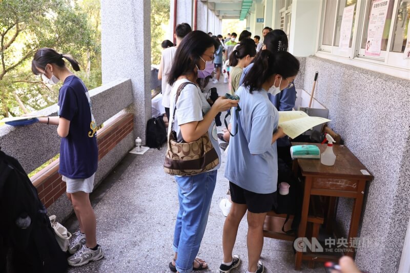 圖為7月12日分科測驗，台北市建國中學考場有考生家長手持電風扇替考生消暑降溫。（中央社檔案照片）
