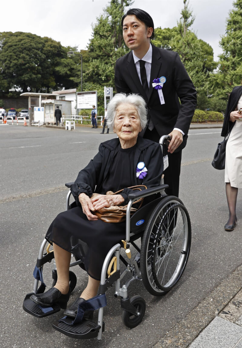 日本政府15日為二戰犧牲者舉行追悼儀式，高齡104歲的人瑞竹內笑子（前）帶著亡夫的「陣亡公報」參加，並立誓反戰。（共同社）