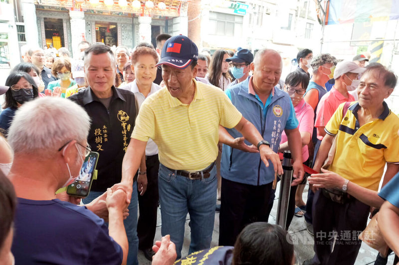 鴻海集團創辦人郭台銘（中）16日下午前往桃園八德霄裡玉元宮參拜，受到現場民眾熱情歡迎，郭台銘也展現親和力與群眾互動。中央社記者吳睿騏桃園攝 112年8月16日