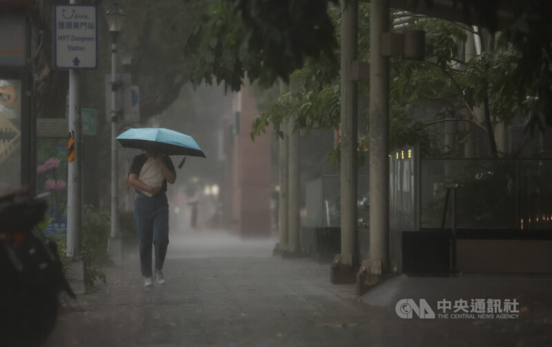 圖為大安區一位民眾走在滂沱大雨中。（中央社檔案照片）