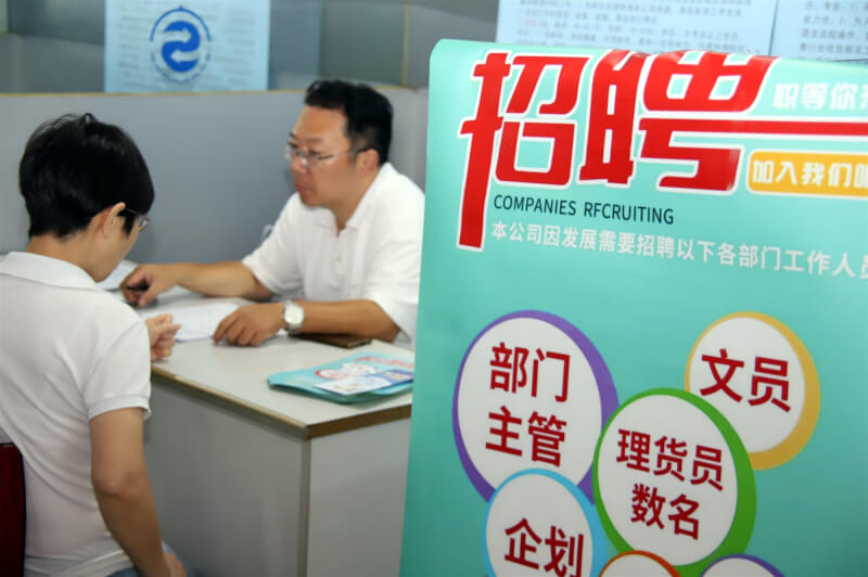 中國江蘇蘇州求職者5日在一場招聘會上與工作人員洽談。（中新社）
