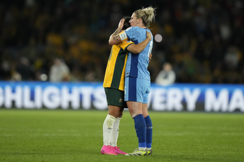 英格蘭女足隊長卜萊特（藍衣）16日率隊擊敗地主澳洲後，上前擁抱安慰情緒激動的澳洲隊長柯爾（黃衣）。（美聯社）