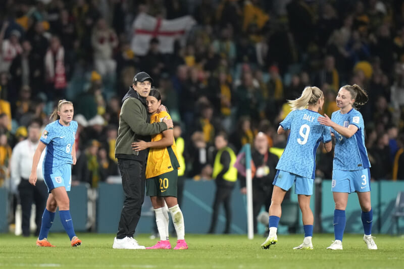 英格蘭隊16日在雪梨7萬5000名觀眾面前，於4強賽以3比1擊敗地主隊澳洲，澳洲隊教練葛斯塔夫松（綠衣）在場中擁抱安慰隊長柯爾（前黃衣者）。（美聯社）