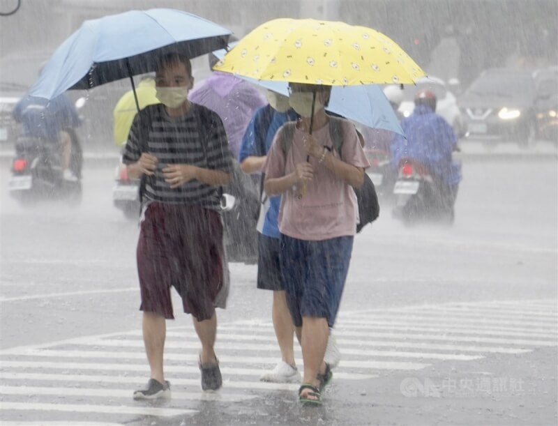 圖為民眾在高雄市新興區頂著大雨撐傘過馬路。中央社記者董俊志攝 112年8月17日