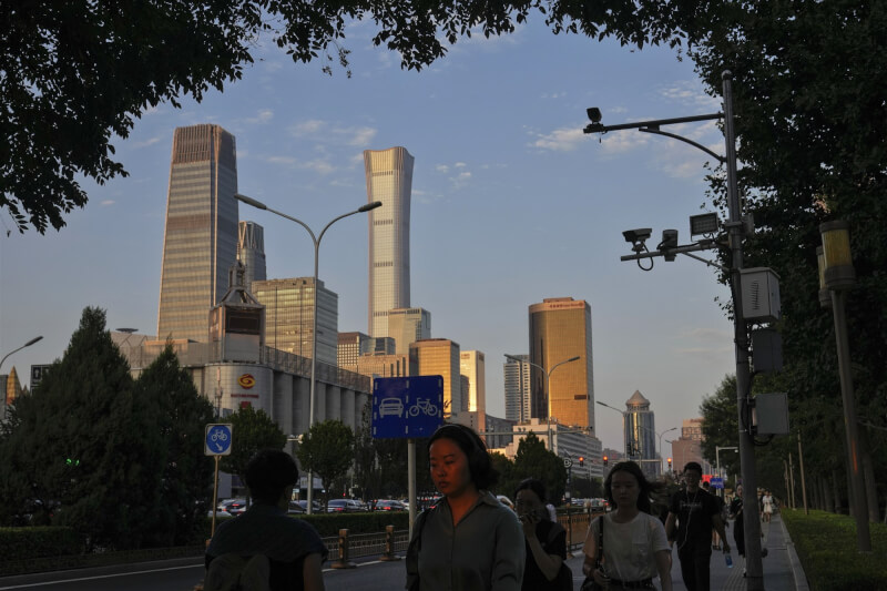 中國疫後經濟復甦力道不如預期，又接連爆出債務危機，前景籠罩陰霾。圖為中國民眾走在北京商務區街道。（美聯社）