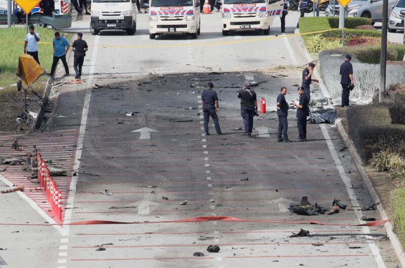 馬來西亞小飛機17日墜機爆炸，造成機上8人、地面上1名機車騎士與1名汽車駕駛喪生。圖為相關人員在失事現場調查。（路透社）