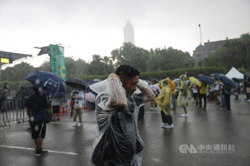 遊行活動開始前下起大雨，民眾紛紛撐傘、穿雨衣遮擋。中央社記者王飛華攝 112年8日20月