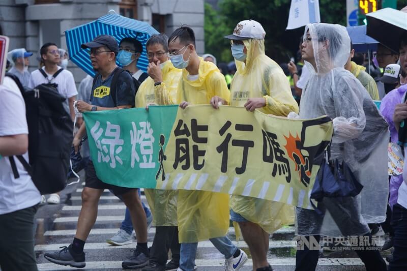 路權團體「行人零死亡推動聯盟」20日下午舉行「還路於民大遊行」，儘管現場一度下起滂沱大雨，仍有大批民眾到場響應，與會者沿途拉布條。中央社記者徐肇昌攝 112年8月20日