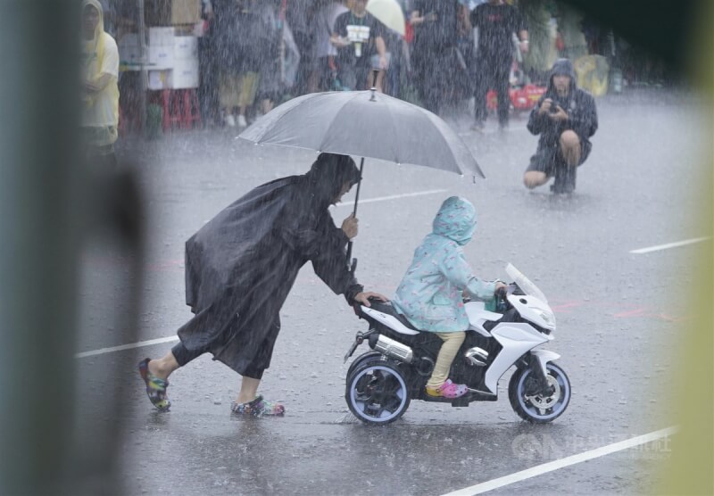 行人零死亡推動聯盟20日下午在凱達格蘭大道舉行「還路於民大遊行」，現場午後下起暴雨，有家長冒雨引導孩子體驗騎乘玩具車。中央社記者徐肇昌攝 112年8月20日