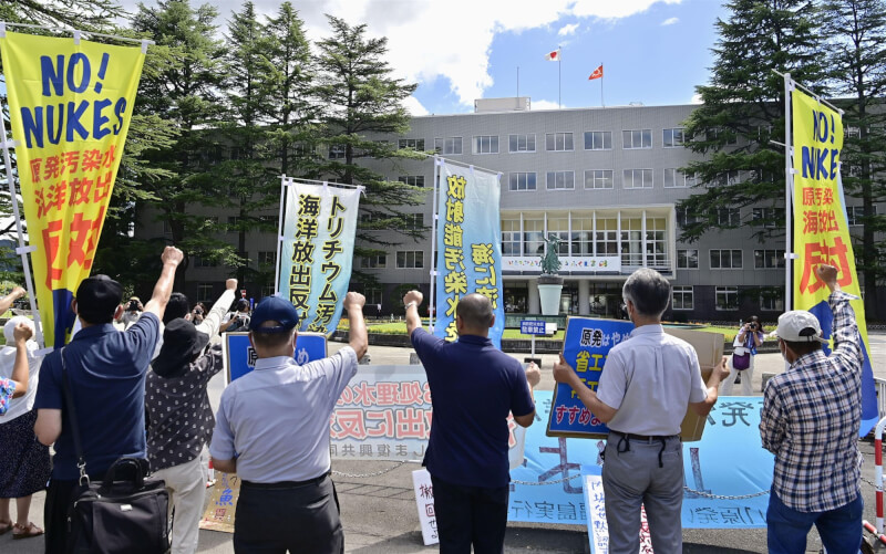 日本政府決定最快8月24日將「核處理水」排放入海，民眾22日舉起「勿將汙染水排放入海」等布條及標語抗議。（共同社）