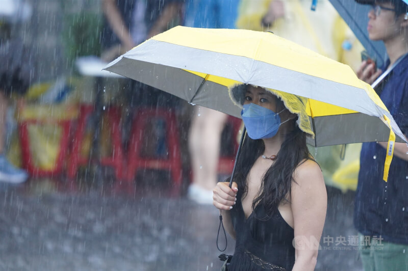 圖為台北市中正區民眾撐傘避雨。（中央社檔案照片）