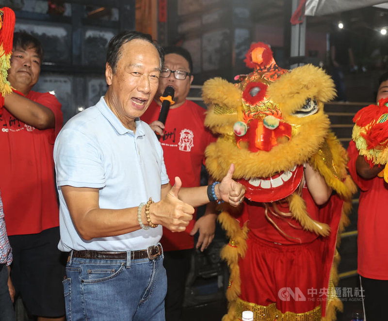 鴻海創辦人郭台銘（前左）22日晚間出席烈嶼三玄宮醮慶活動，廟方邀請醒獅團到場表演，郭台銘起身比讚。中央社記者鄭清元攝 112年8月22日