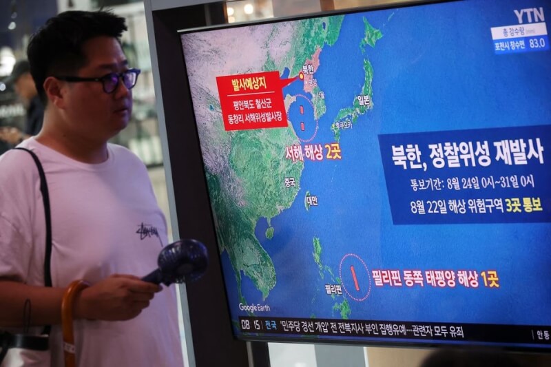 圖為民眾24日在首爾火車站觀看電視新聞播報北韓發射軍事偵察衛星的新聞。（路透社）