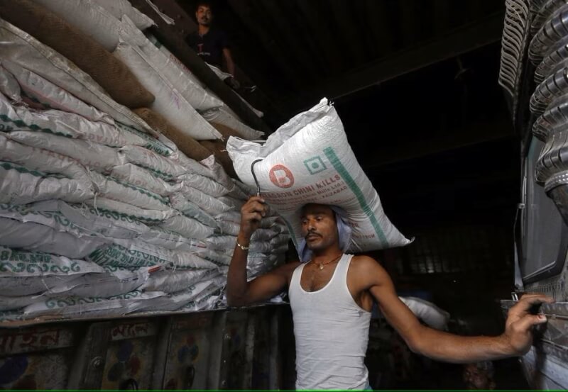 圖為印度工人搬運袋裝糖。（路透社）
