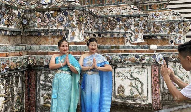 曼谷鄭王廟前，觀光客穿上泰國傳統服裝，雖然下起小雨，但仍不減拍照心情，開心留下泰服美照。中央社實習記者李書瑜曼谷攝 112年8月26日