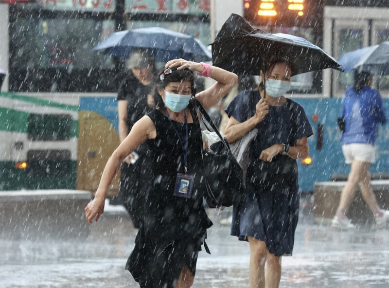 中央氣象局研判，颱風蘇拉下週將影響台灣，8月30日至9月1日，全台有雨，東半部應防大雨。圖為台北市中正區午後雨勢滂沱，未帶雨具民眾緊急以手遮擋。（中央社檔案照片）