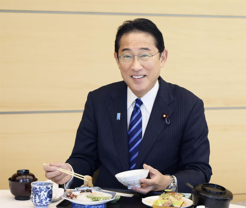 日本首相岸田文雄30日在首相官邸大啖福島產水產品，對外展現當地水產品的安全性。（共同社）