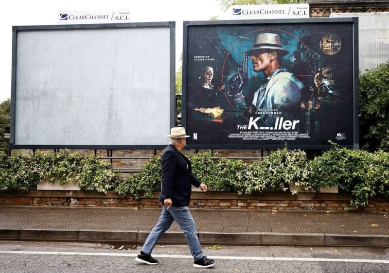 圖為第80屆威尼斯電影節開幕式前夕，一名男子走過電影「殺手」海報。（路透社）