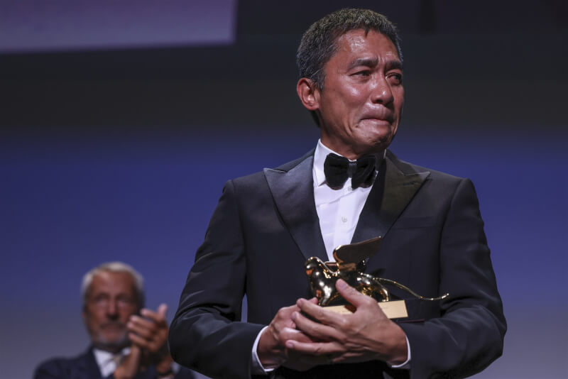 香港影帝梁朝偉2日在威尼斯影展從名導李安手上接下終身成就獎。（美聯社）