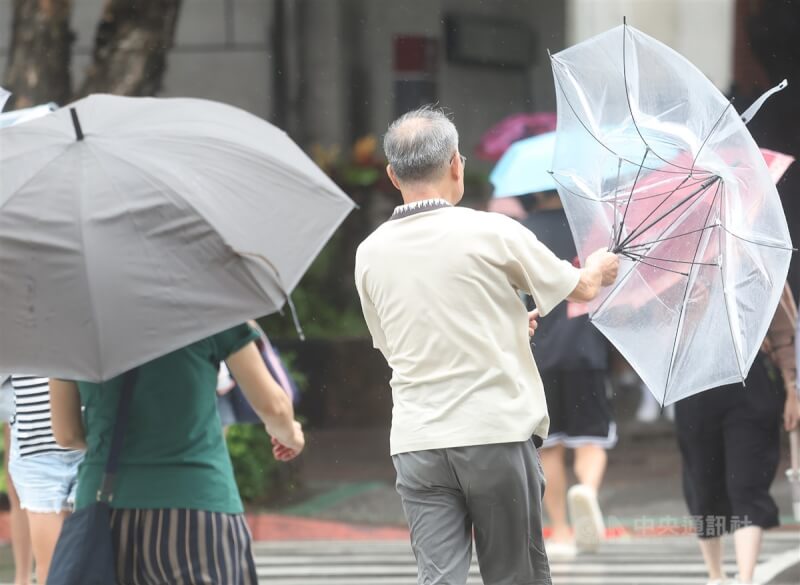 颱風海葵襲台，3日午後台北市大安區街頭民眾雨傘一度被瞬間強風吹翻。中央社記者張新偉攝 112年9月3日